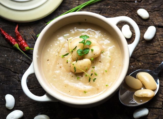 Creamy white bean soup on wooden background