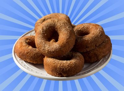 A plate of apple cider doughnuts set against a vibrant background.