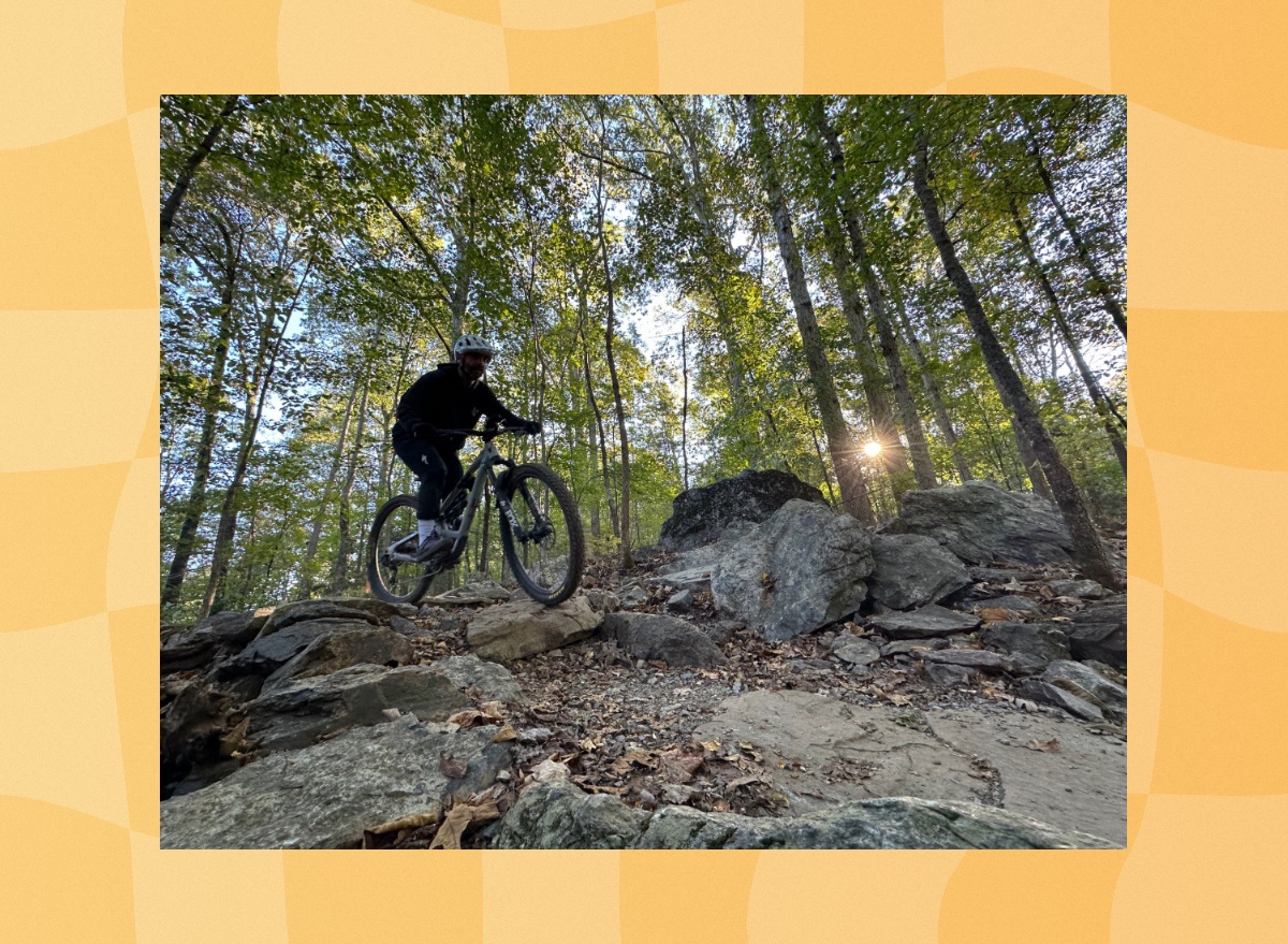 man mountain biking through woodsy trail