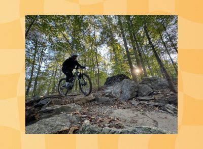 man mountain biking through woodsy trail