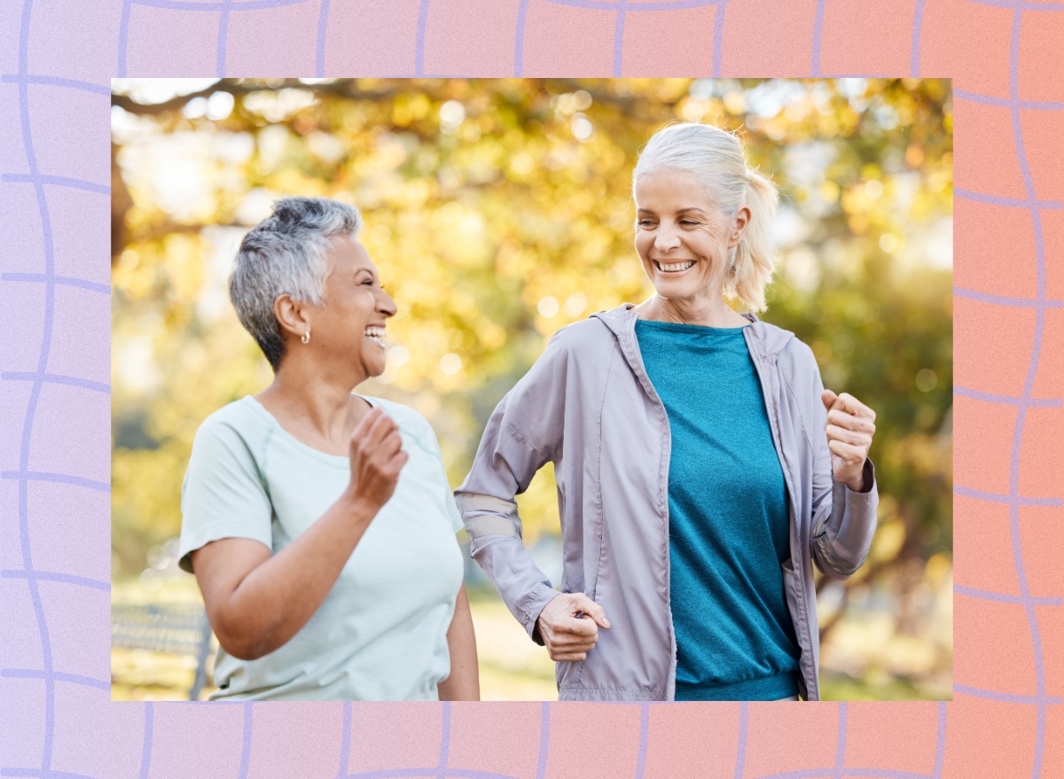 two mature female friends walking outdoors for exercise on sunny fall afternoon