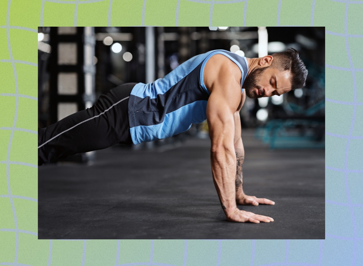 fit, muscular man doing pushups in dark gym