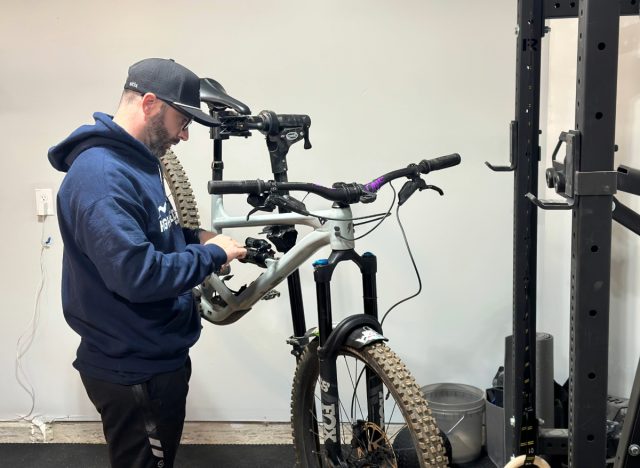 trainer setting up his mountain bike in the garage for the trails