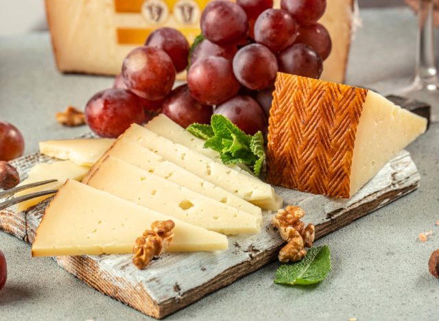 Spanish manchego on a board with grapes and walnuts