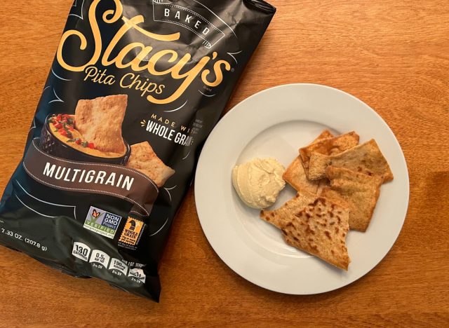 Stacy's Multigrain Pita Chips on a plate with hummus next to a bag of the pita chips