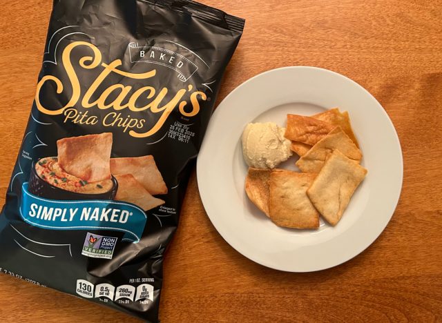 Stacy's Simply Naked pita chips on a plate with hummus next to a bag of the pita chips