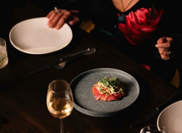 a plated dish at Vecino next to a glass of wine