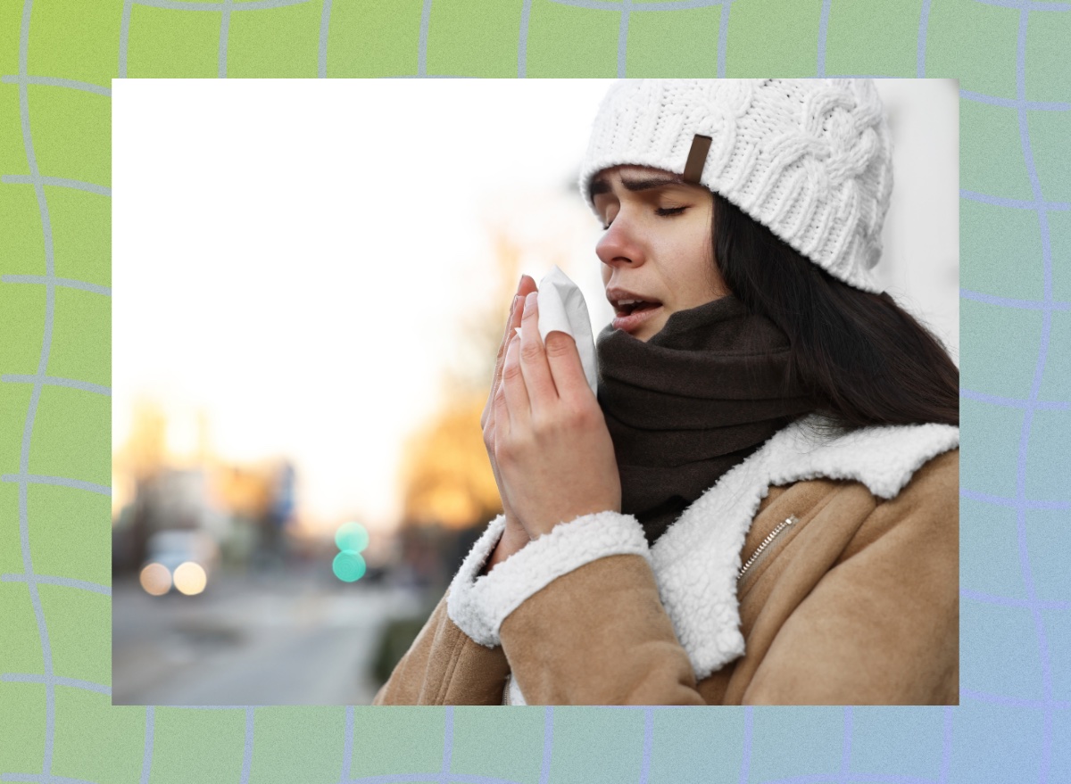 brunette woman bundled up in the cold weather outdoors, holding a tissue, ready to sneeze