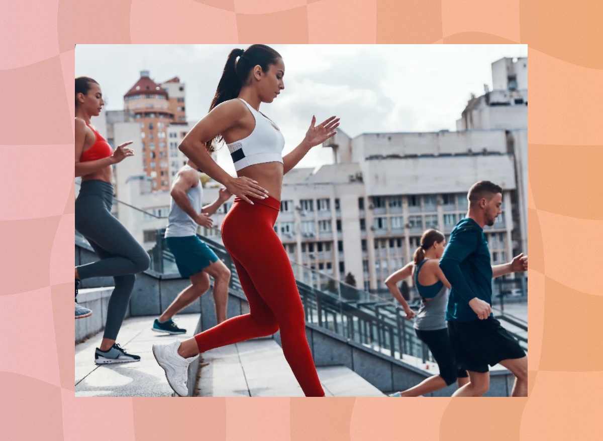 fit brunette woman in a running group sprinting down steps outdoors