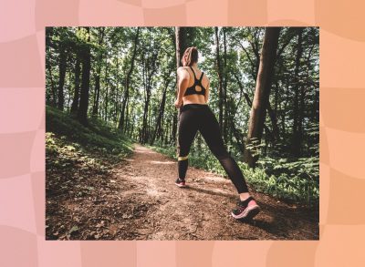 fit woman walking uphill on trail in the woods for exercise