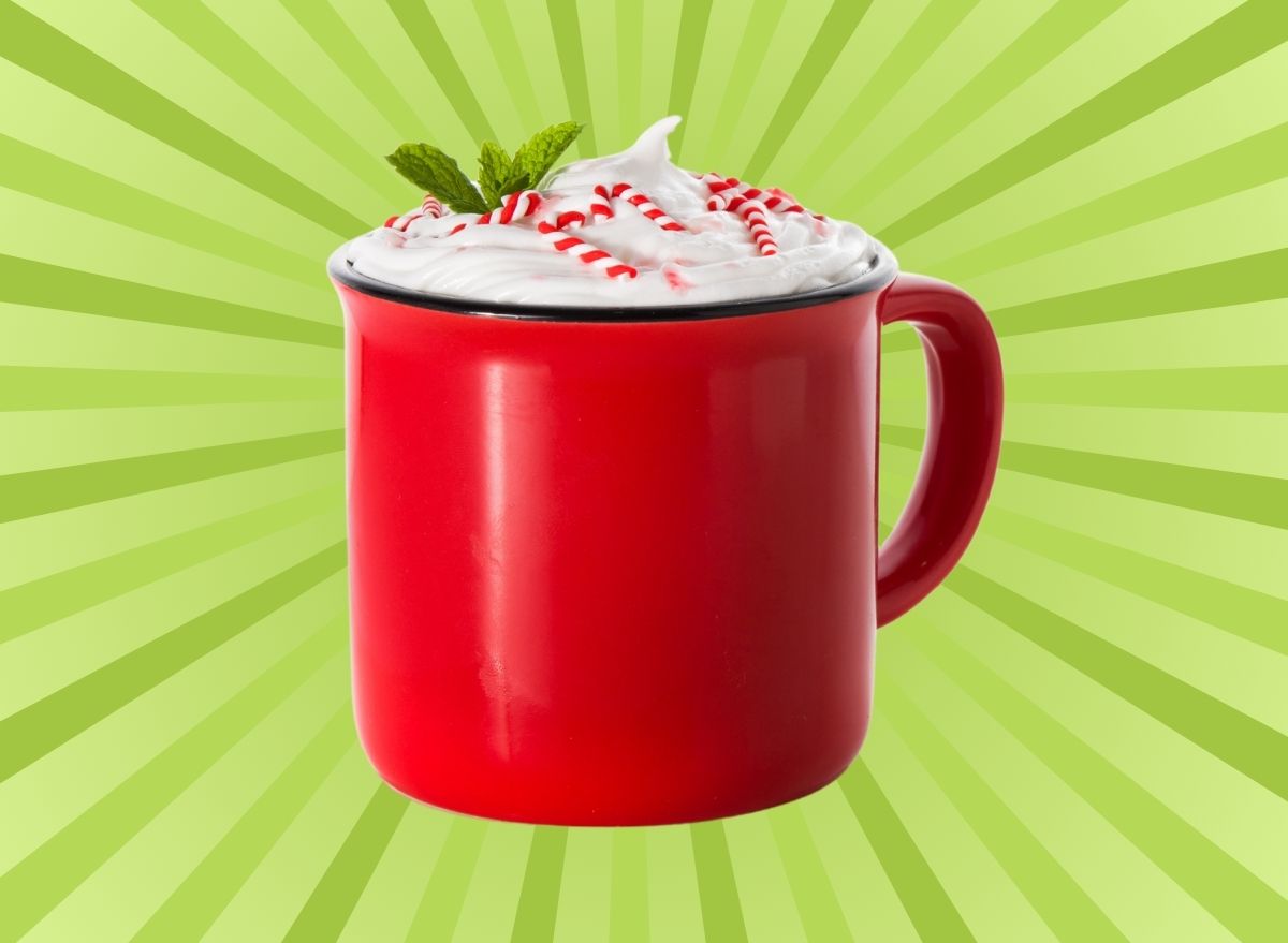 A mug of peppermint mocha with whipped cream, set against a vibrant background.