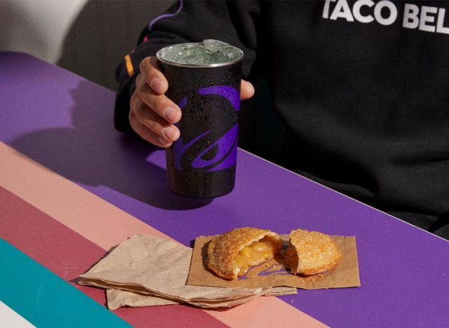 Taco Bell Caramel Apple Empanada and soft drink on table