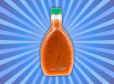 isolated image of a bottled salad dressing on a burst blue background