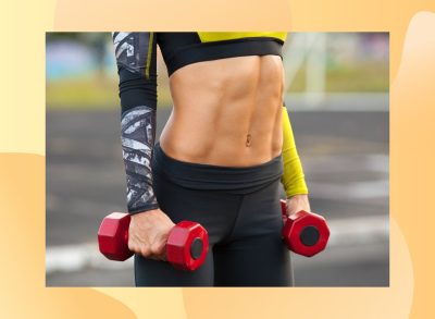 close-up of a woman with six-pack abs holding dumbbells, getting ready to work out