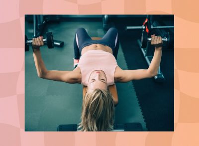 woman doing a dumbbell bench press exercise at the gym