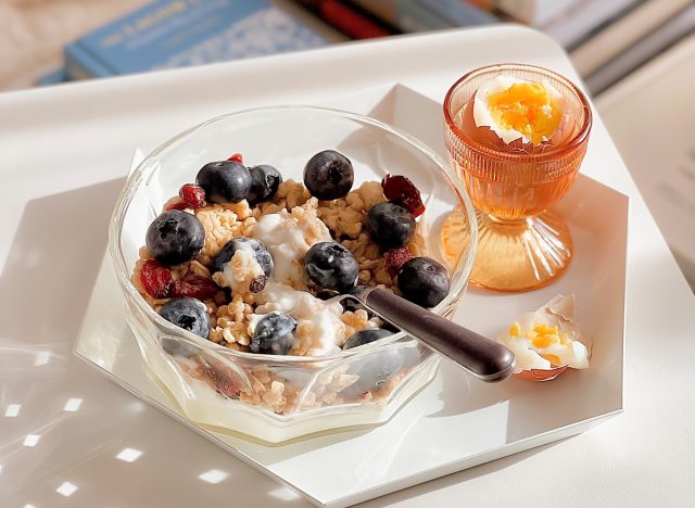 bowl of berry yogurt and granola with an egg