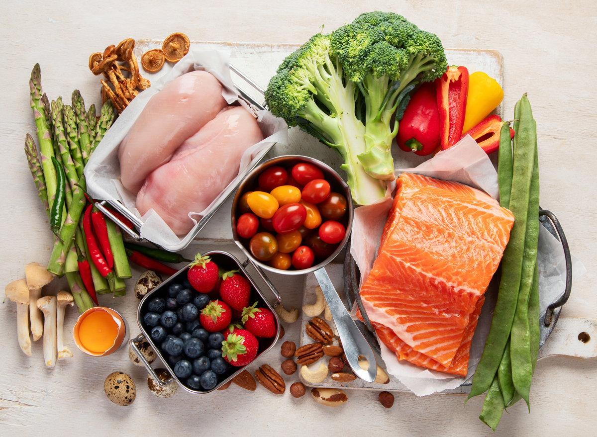 Vegetables, fish, meat, nuts, seeds, berries, cheese on a white background, top view.