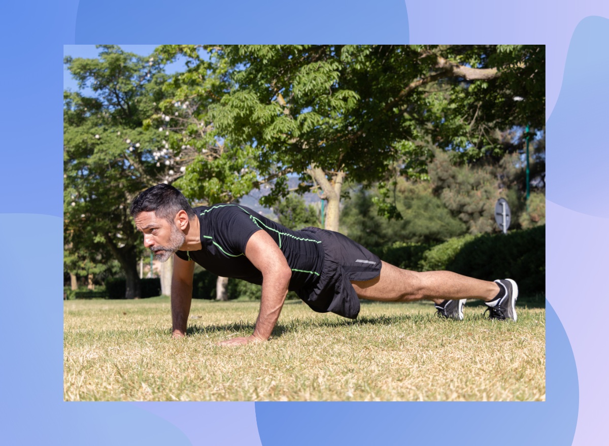 fit, focused middle-aged man doing pushups outdoors on the grass on a sunny day