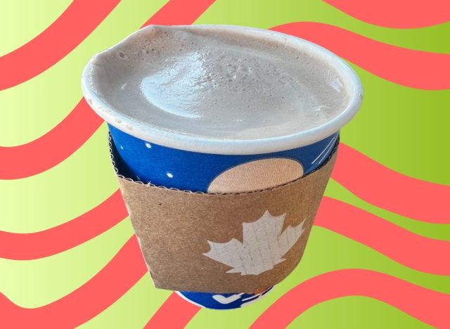 A cup of Tim Hortons' popular peppermint mocha set against a festive, holiday-themed background.