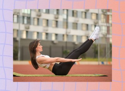 brunette woman doing pilates ab exercise on mat on track outdoors