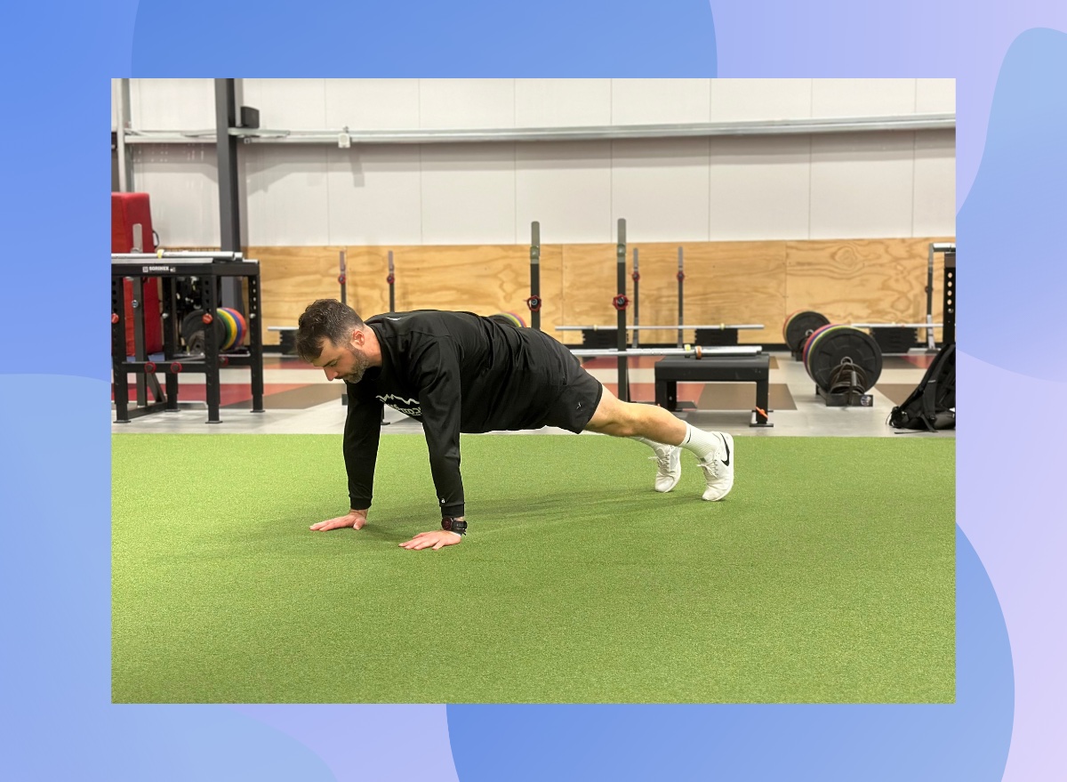 trainer performing a pushup from the set-up, high plank position