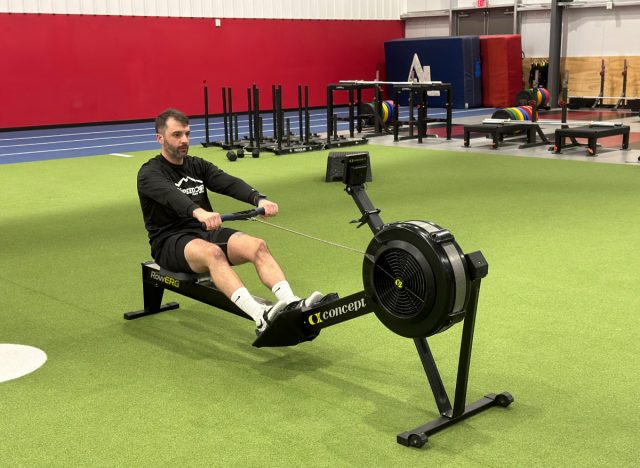 personal trainer doing a rowing workout at the gym