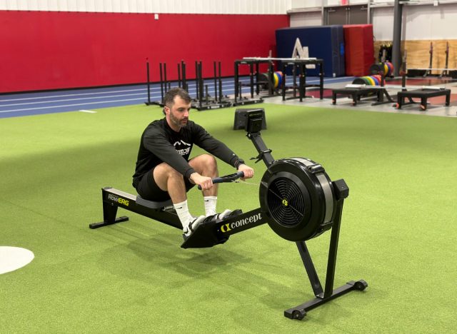 personal trainer doing a rowing workout at the gym