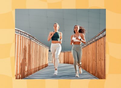 two fit women running outdoors on small bridge