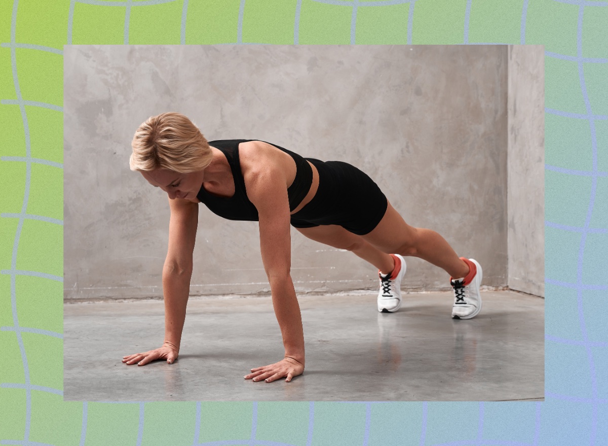 fit blonde woman doing high plank exercise in front of gray wall