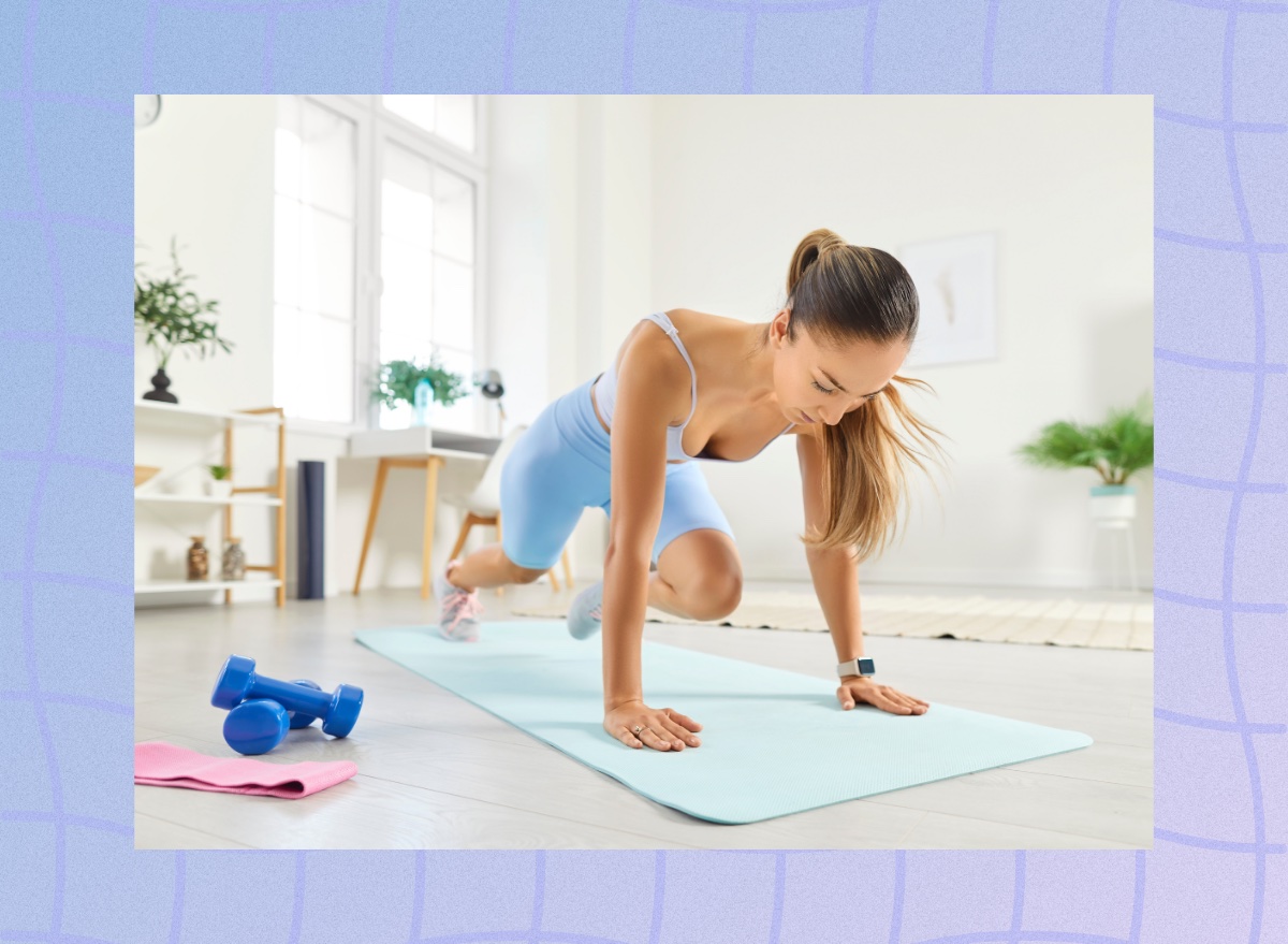 woman doing mountain climber exercise at home on yoga mat in bright living room area