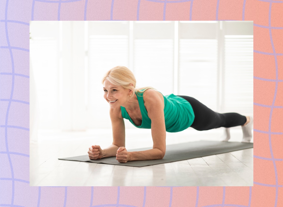 fit mature woman doing forearm plank in bright room