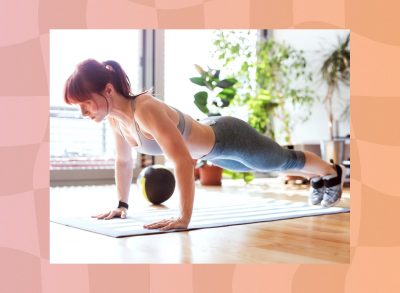 focused woman doing pushup on workout mat at home in bright living space