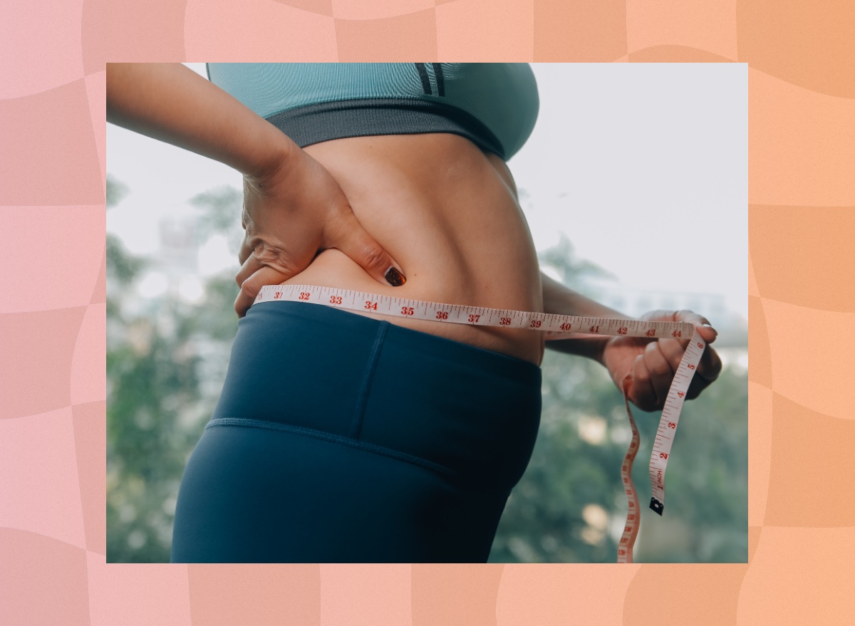 close-up of woman measuring belly fat