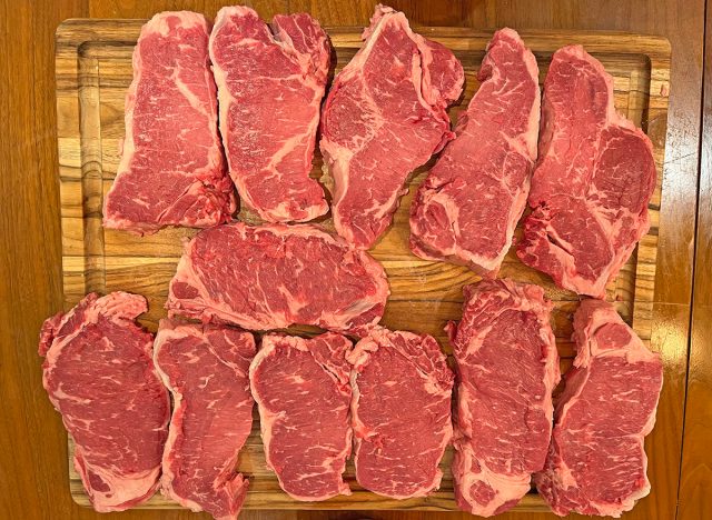 An array of New York stip steaks, freshly carved from a whole loin, bought at Costco