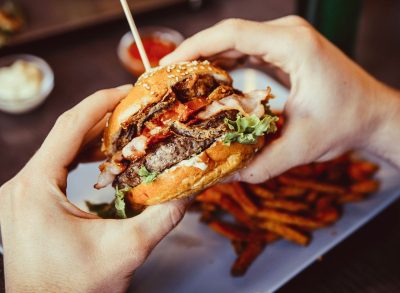 Customer eating burger at restaurant