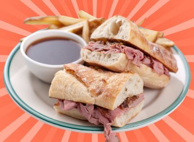 A classic French dip sandwich with fries and au jus set against a vibrant background