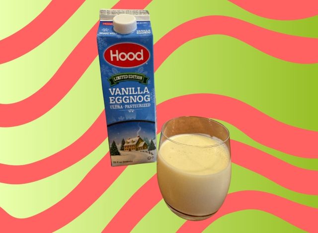 A carton of Hood eggnog beside a glass of the beverage set against a festive background