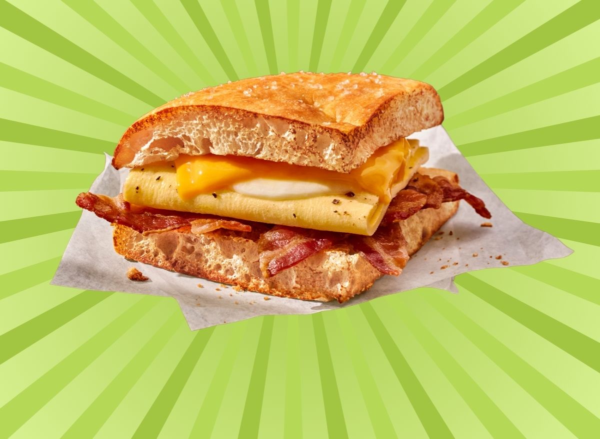 A closeup of Panera's Bacon Double Take breakfast sandwich set against a vibrant background