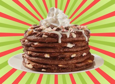 A stack of chocolate peppermint pancakes at IHOP set against a festive background