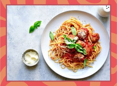 a plate of spaghetti and meatballs on a designed background