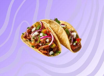 Two soft-shell tacos on a graphic background