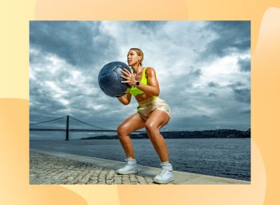 fit woman holding medicine ball while squatting