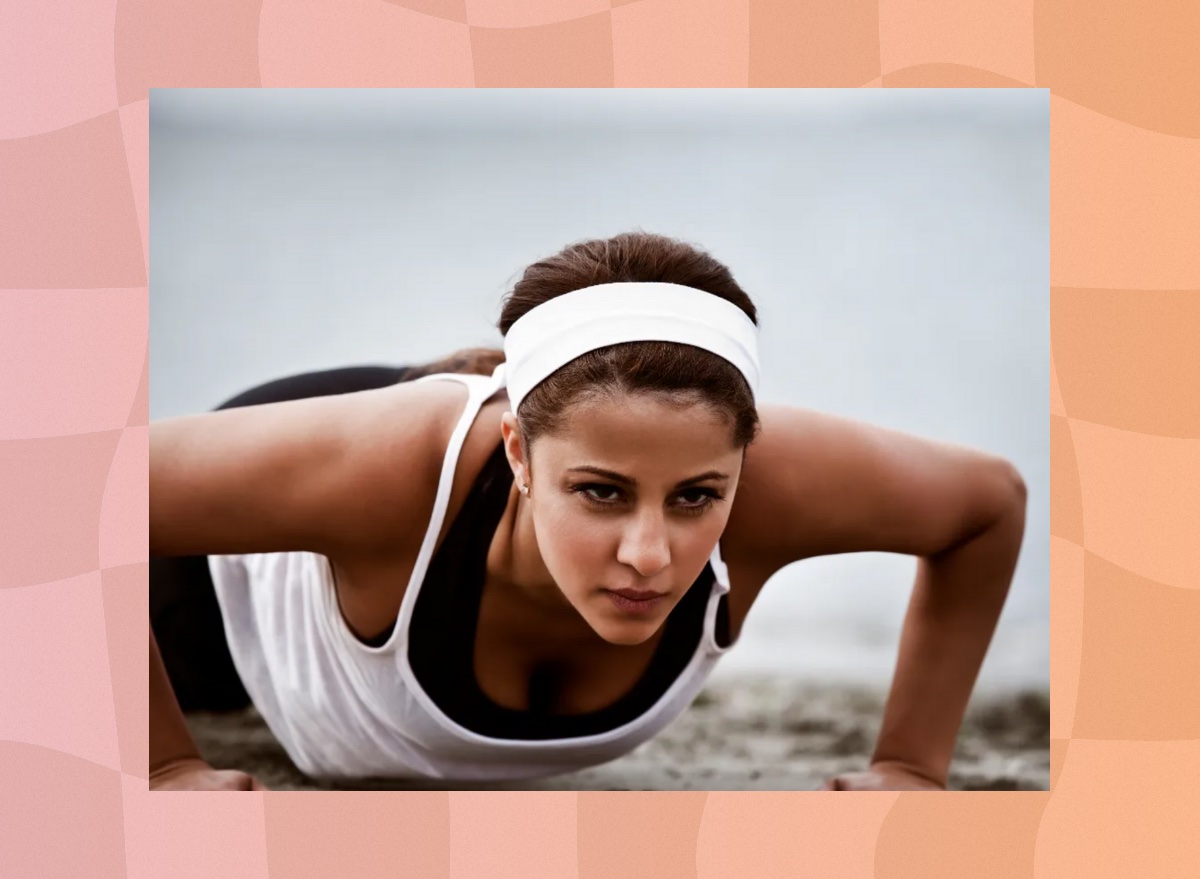 fit, focused woman doing pushups on the beach