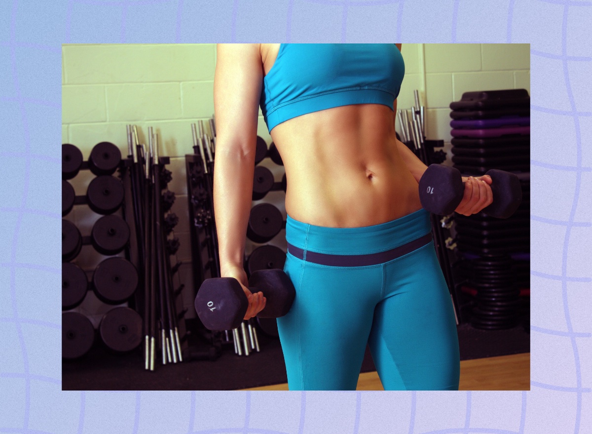 close-up of woman holding dumbbells in weight room