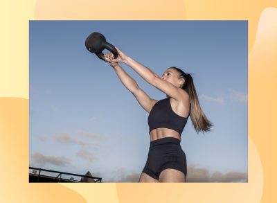 fit woman doing kettlebell swing outdoors at dusk