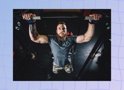 fit, muscular man doing pull-ups in dark gym