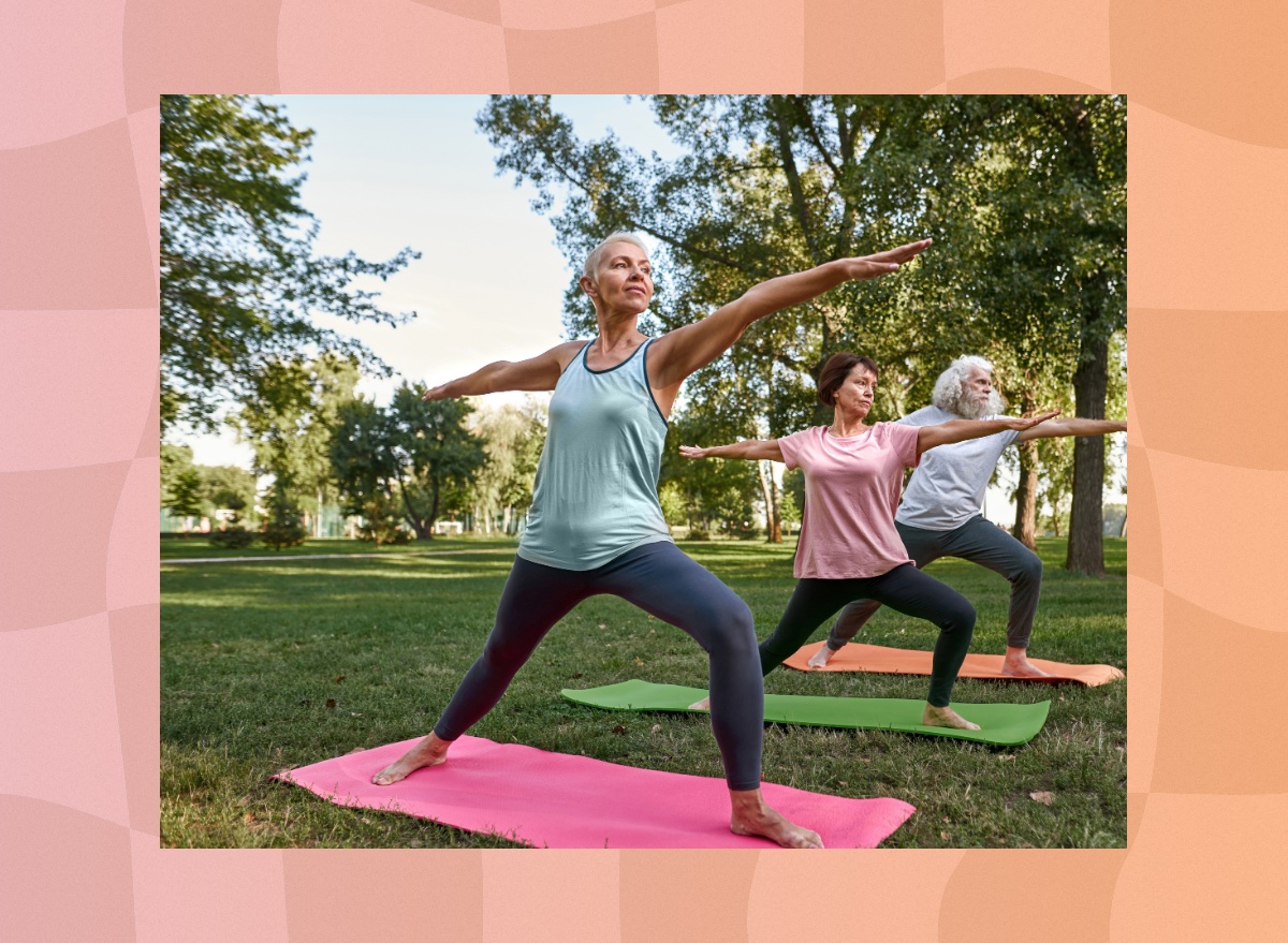 mature group doing outdoor yoga class in park