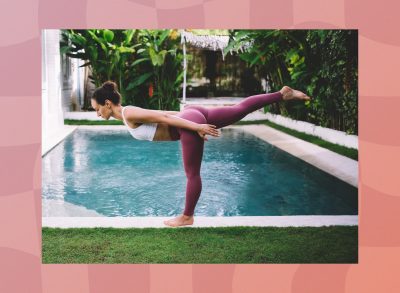 brunette woman doing warrior III pose in front of pool