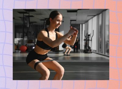 fit brunette woman doing resistance band squat at the gym