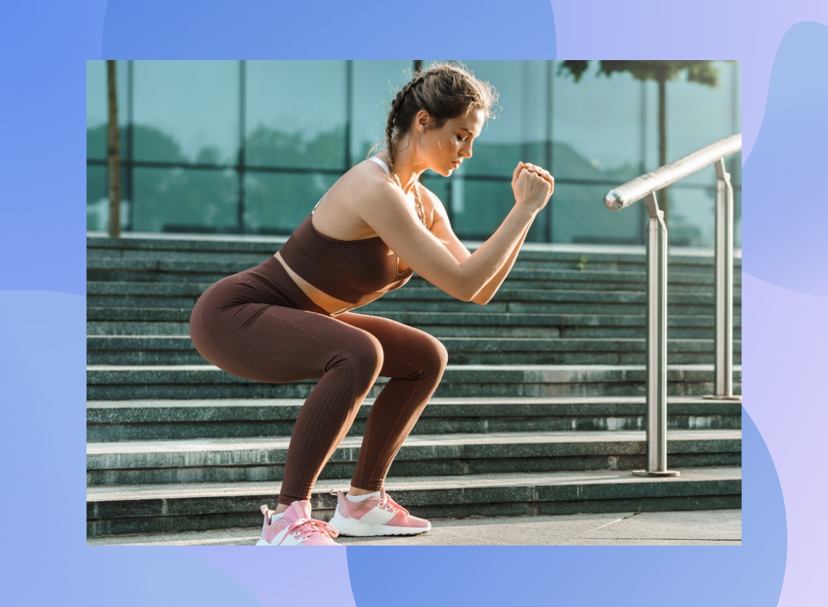 fit, focused woman doing bodyweight squats outdoors near set of stairs